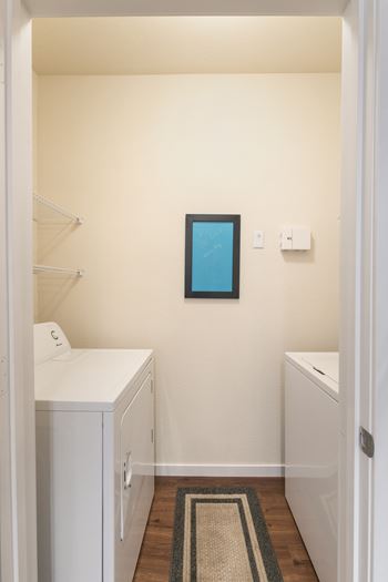 A small bathroom with a white cabinet and a small mirror above it.